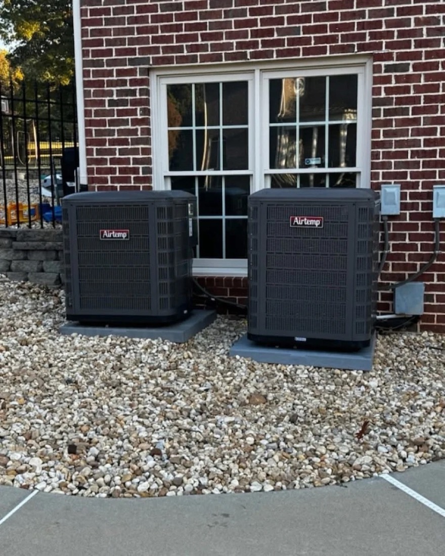 Two Carrier outdoor AC condenser units installed side-by-side by Dynasty at a red-brick Atlanta home